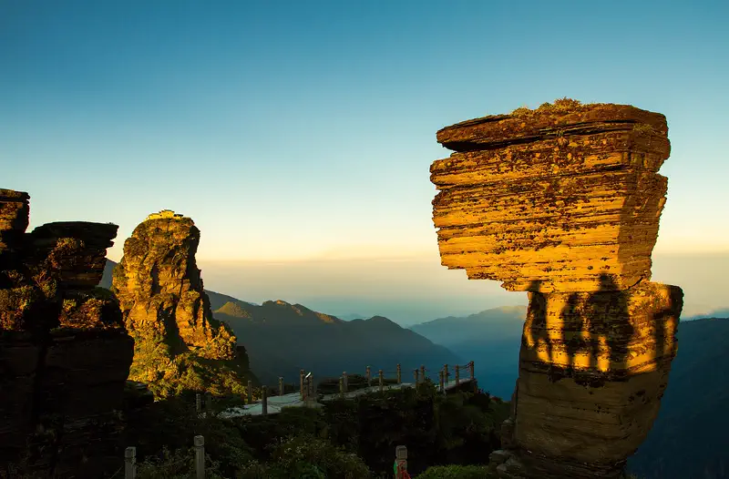 Fanjingshan: sunlit rock pillars rising above a hazy mountain landscape
