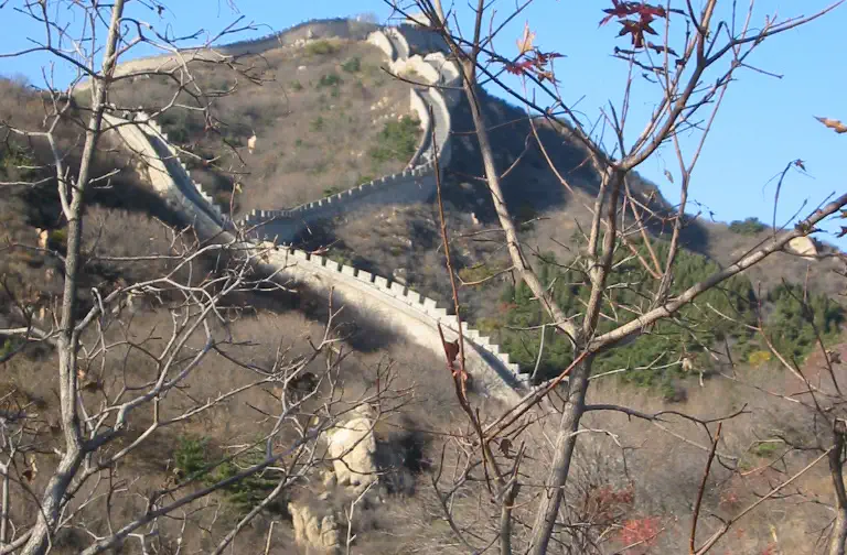 Great Wall: stone wall winding along a hillside ridge under blue sky