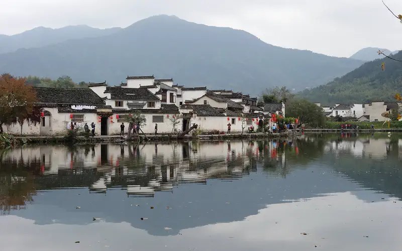 Hongcun Ancient Village: white buildings with dark roofs reflected in calm water