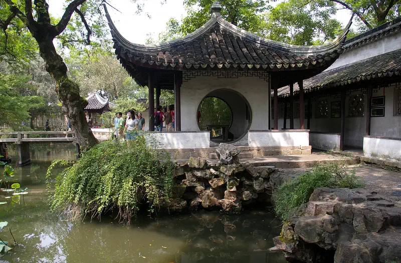 Humble Administrator Garden lotus pond with Scholar Rock and covered walkway in Suzhou