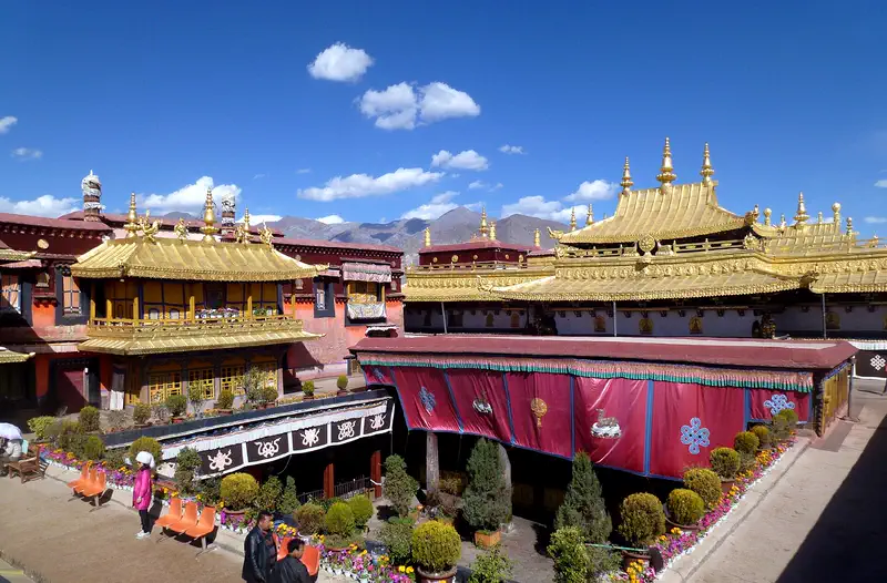 Jokhang Temple: gilded roofs of the temple seen from above, with mountains beyond