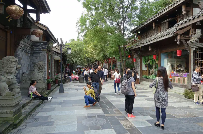 Kuanzhai Alley: a paved lane of grey-brick and timber buildings with stone lions and visitors