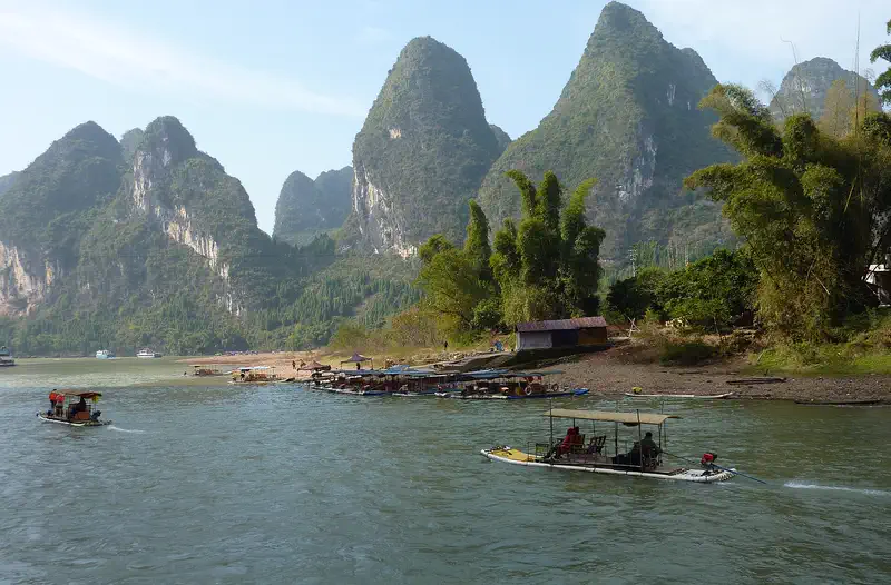 Li River Cruise (Guilin to Yangshuo): small boats on the river with green karst hills along the bank