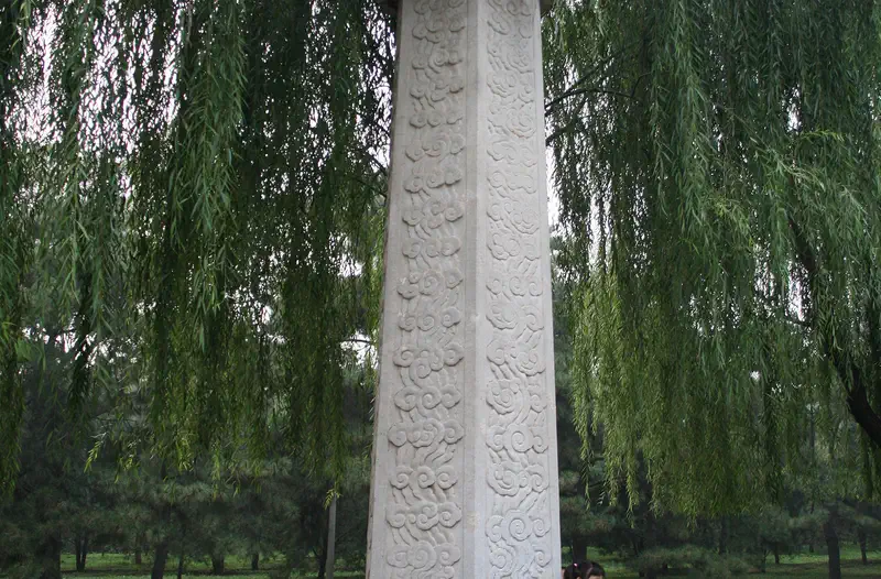 Ming Tombs and Sacred Way: tall carved white stone pillar standing in a grassy park among trees