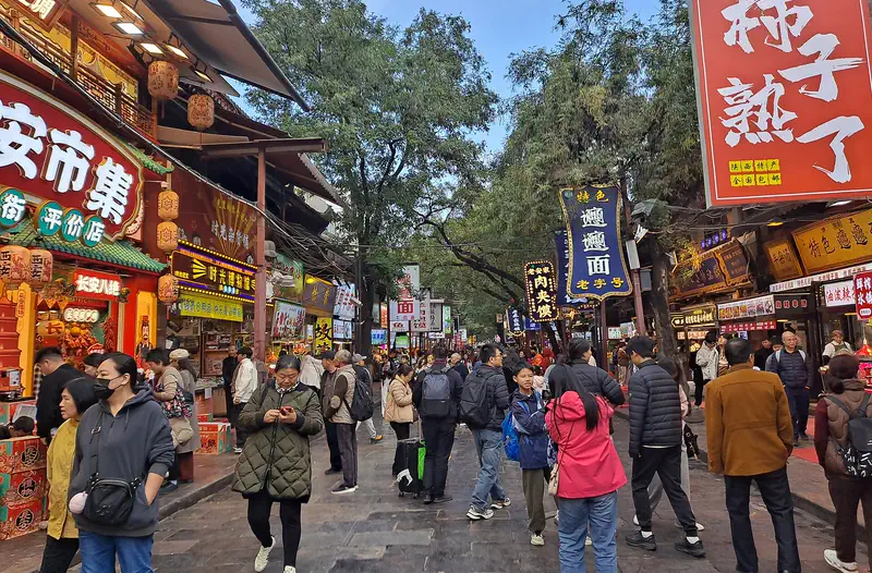 Muslim Quarter (Beiyuanmen Street), Xi'an: crowded pedestrian street lined with shops and hanging red signs