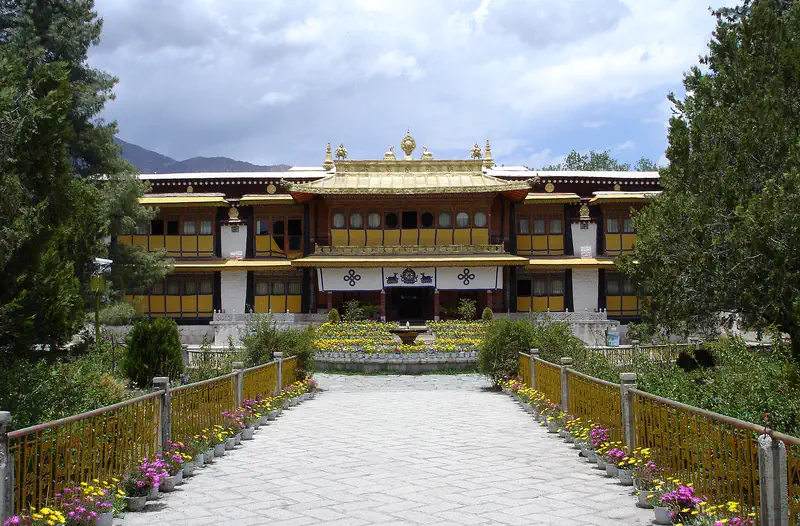Norbulingka: a path between flower beds leading to the gold-roofed New Summer Palace