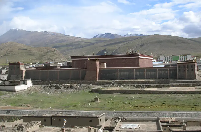 Sakya Monastery: large fortress-like building with dark red and white walls set below barren mountains