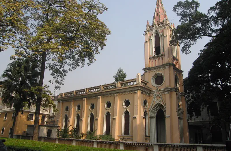 Shamian Island: colonial-style building with a tall tower and arched windows, surrounded by mature trees