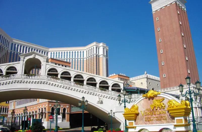 The Venetian Macau: ornate stone bridge and tower resembling Venetian architecture under a clear blue sky