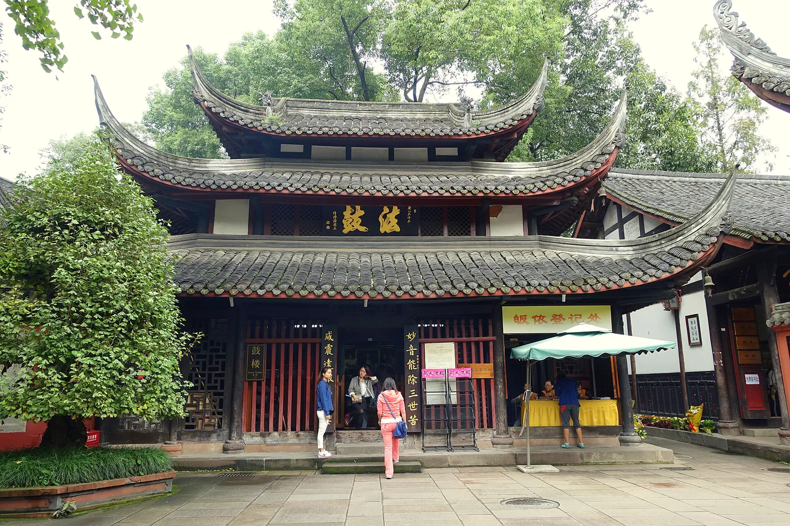 Wenshu Monastery: temple building with curved tiled eaves and a courtyard where visitors are walking