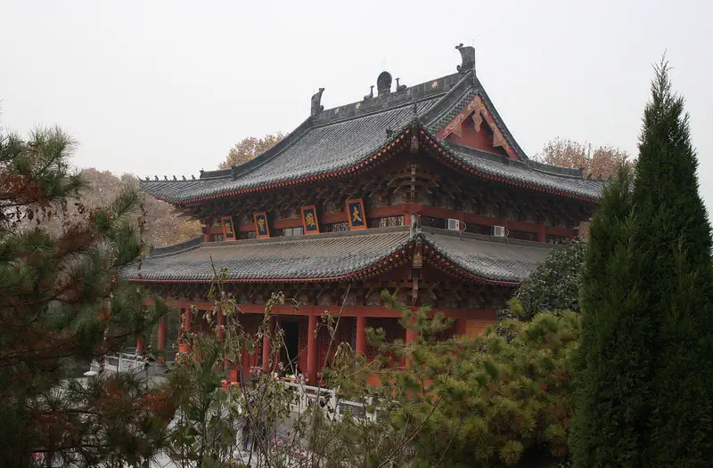 White Horse Temple: traditional multi-tiered temple building with grey tiled roofs, framed by trees