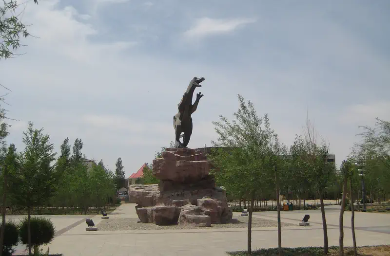 Erenhot: bronze statue on a pedestal in an open plaza under blue sky