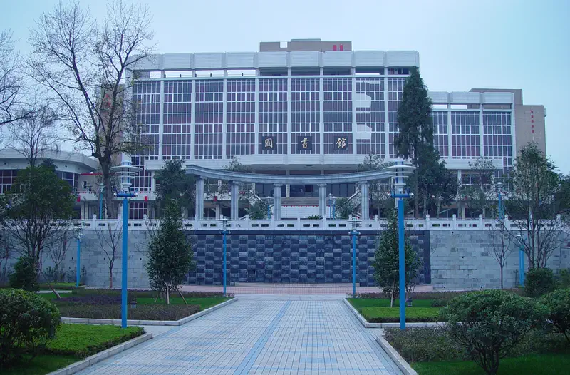 Guiyang: modern building with a paved walkway and trees under blue sky