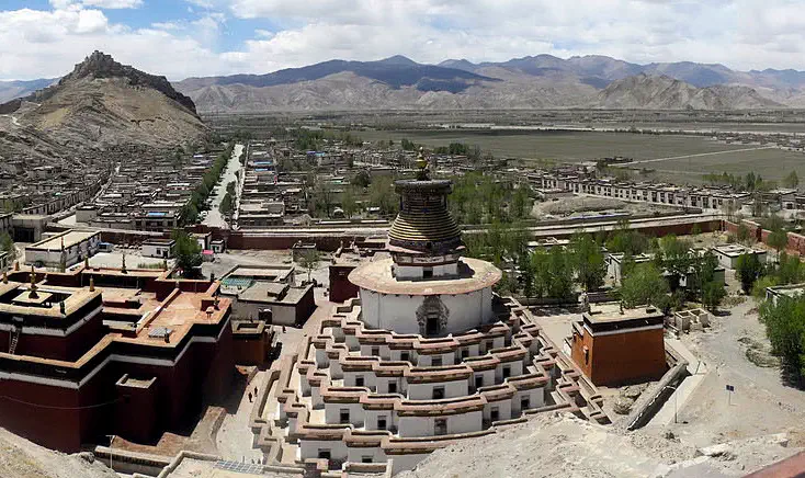 Gyantse: elevated view of a hilltop fort complex with surrounding mountains