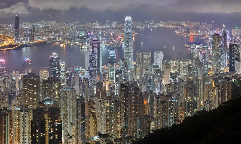 Hong Kong: dense skyscrapers around Victoria Harbour at night, seen from above