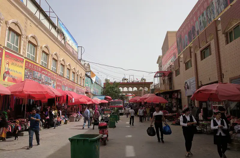 Hotan: a market street of the Grand Bazaar lined with red awnings and shoppers