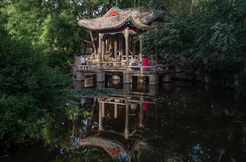 Jinan: a timber pavilion reflected in a pool at Baotu Spring park