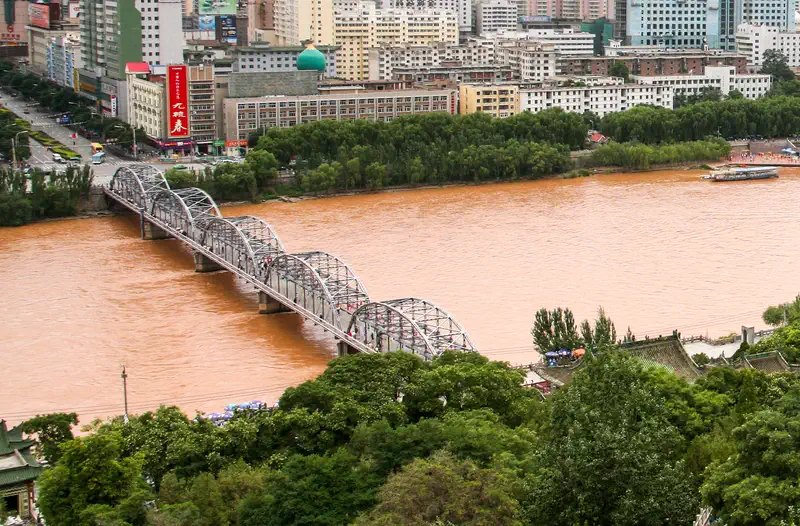 Lanzhou: the iron Zhongshan Bridge crossing the muddy Yellow River, with the city beyond