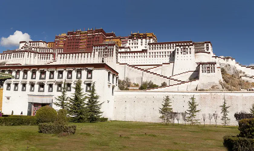 Lhasa: the white and red Potala Palace on its hill above a lawn, under a clear sky