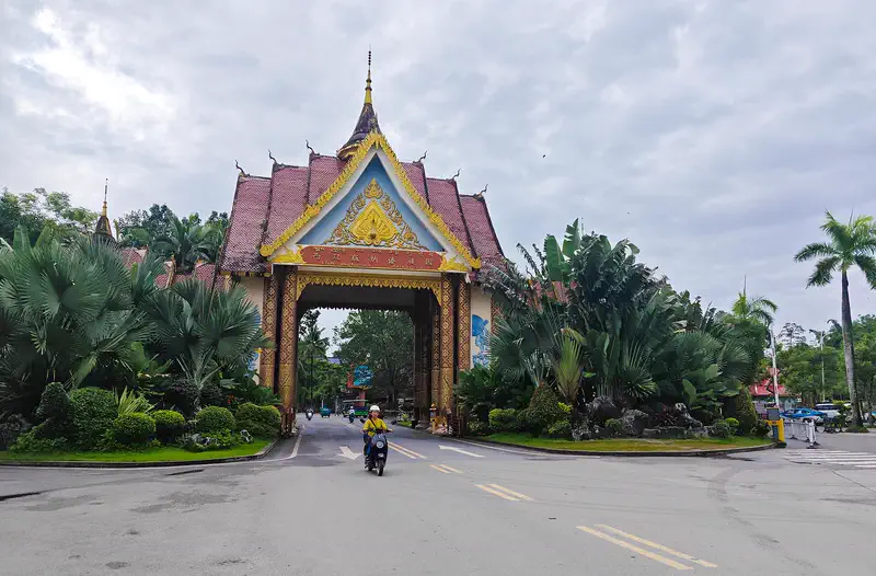 Xishuangbanna: the gilded Dai-style gate of the Dai Nationality Garden in Jinghong, framed by palms