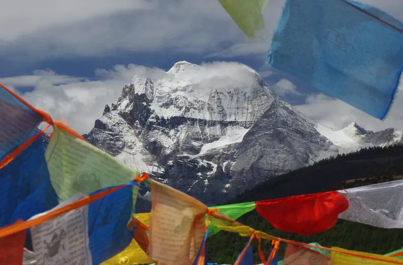 Yading: the snow peak Xiannairi seen through strings of prayer flags