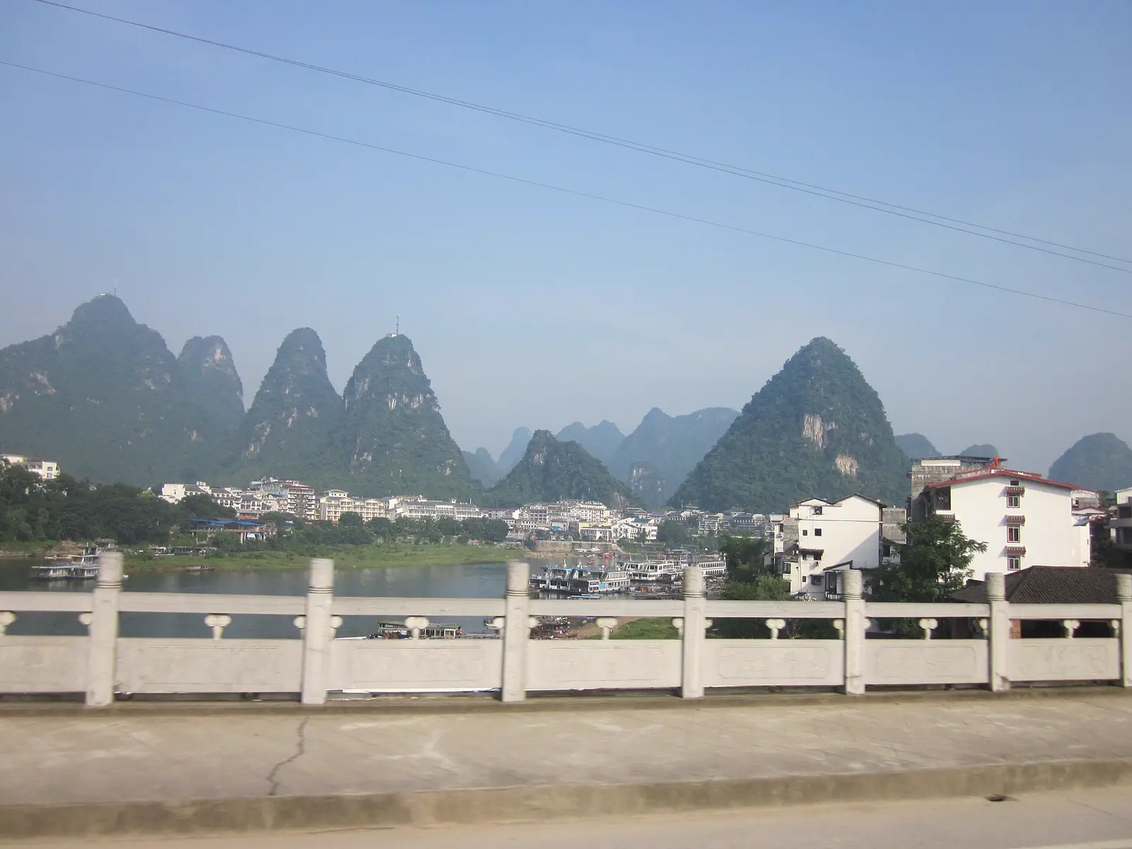 Yangshuo: karst peaks along a river viewed from a paved riverside path