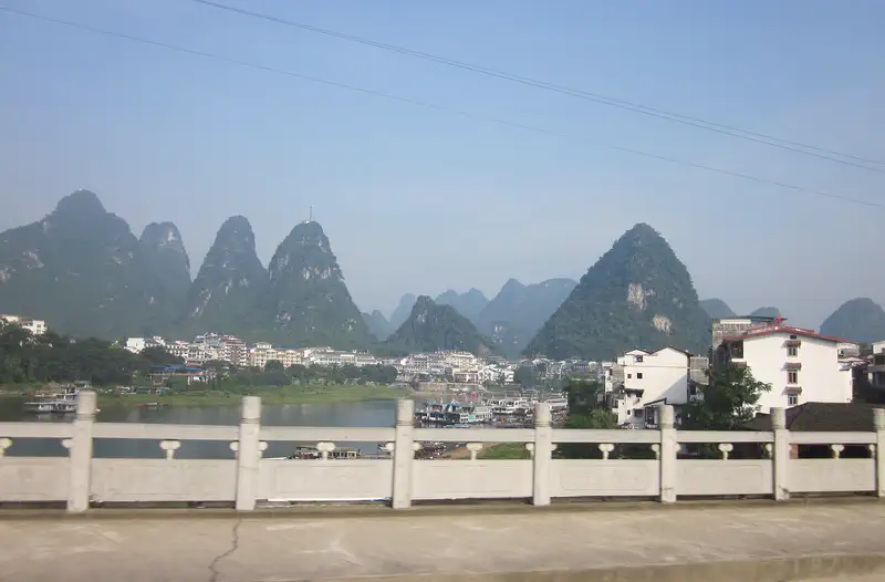 Yangshuo: karst peaks along a river viewed from a paved riverside path