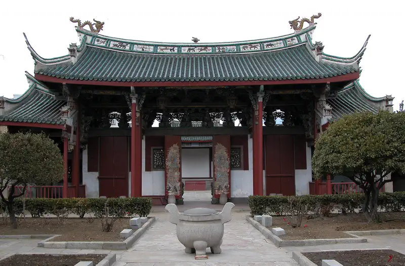Yantai: temple building with a green tiled roof and a courtyard incense burner
