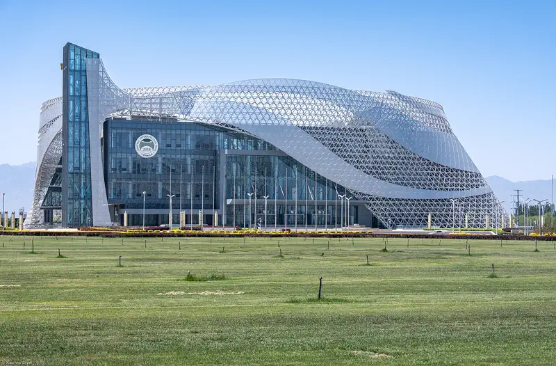Yinchuan: the curved glass-and-steel Ningxia International Hall beyond a lawn
