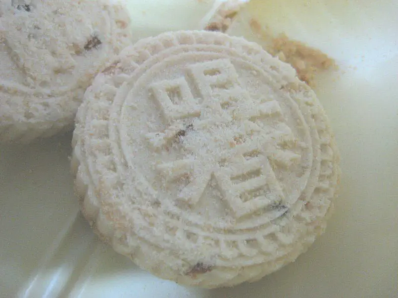 Macau Almond Cookies: close-up of round pale cookies with a stamped decorative pattern on top