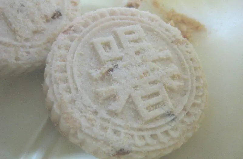 Macau Almond Cookies: close-up of round pale cookies with a stamped decorative pattern on top