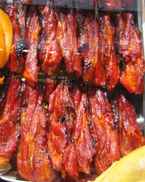 Char Siu (BBQ Pork): rows of glossy red-glazed roasted meat pieces hanging on display